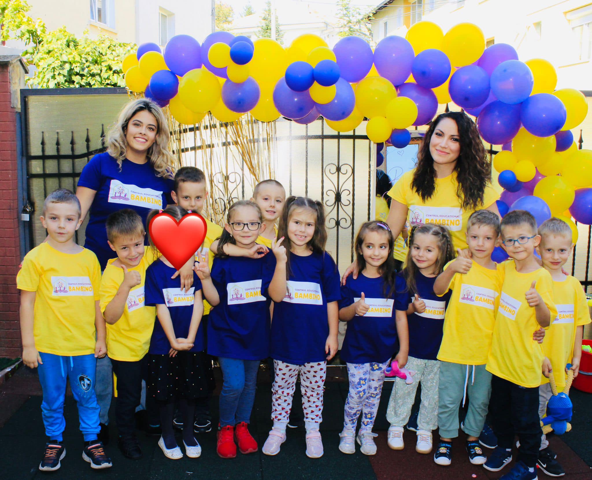 Copii și adulți cu baloane colorate.