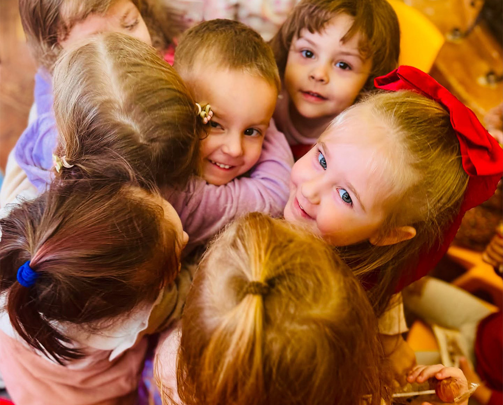 grup de copii ce se imbratiseaza